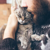 Man cuddling pet cat